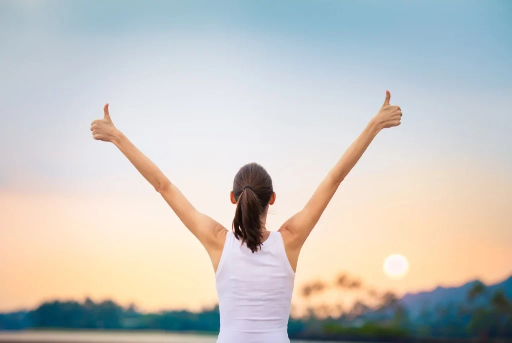 woman facing away giving two thumbs up